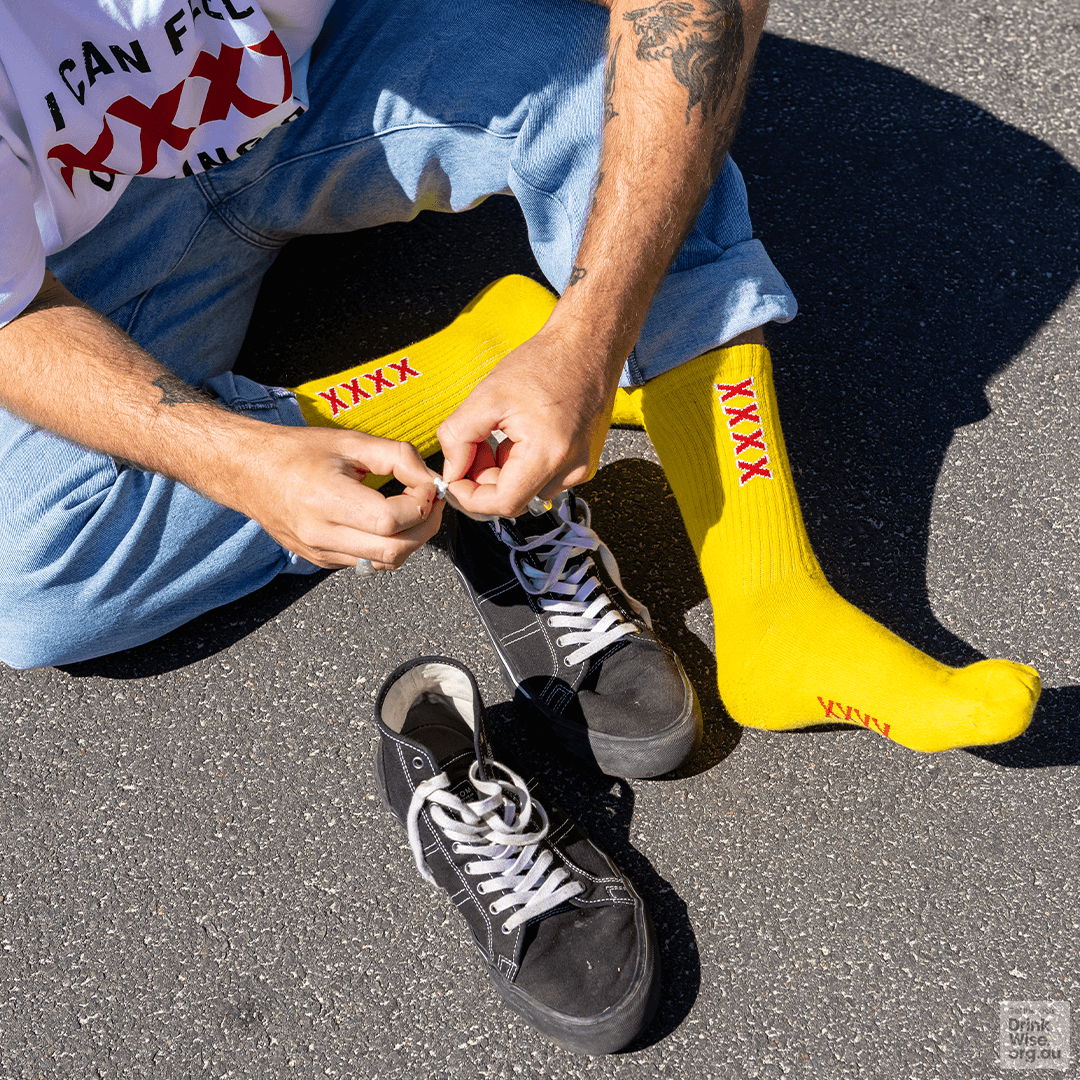 A man wearing yellow XXXX tube socks