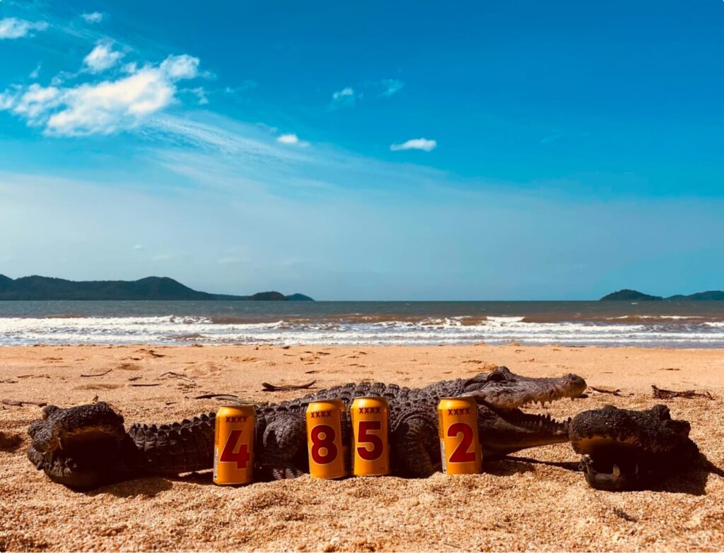 XXXX cans that spell "4852" in front of a saltwater croc